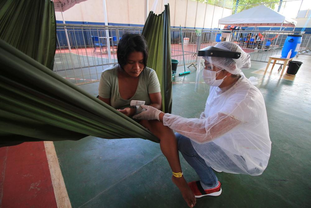 Health team measure the blood pressure of an indigenous Warao woman monitored for COVID-19