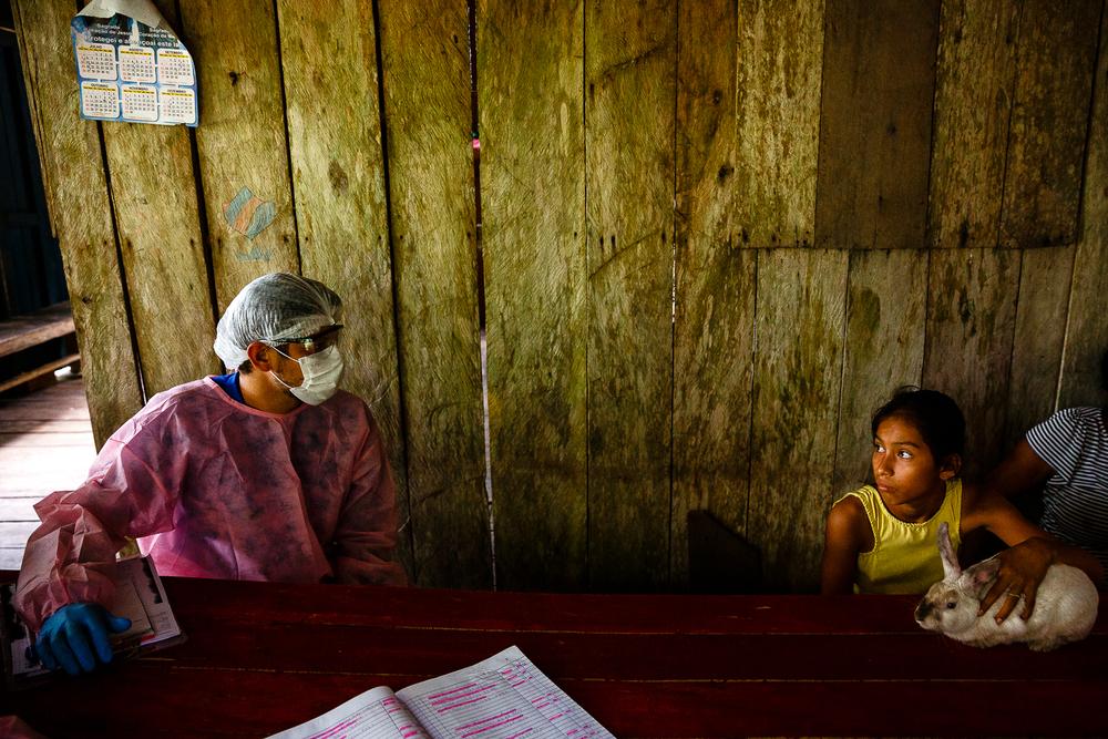 Municipal health system's worker talks to family during house-to-house visit in lake Mirini region