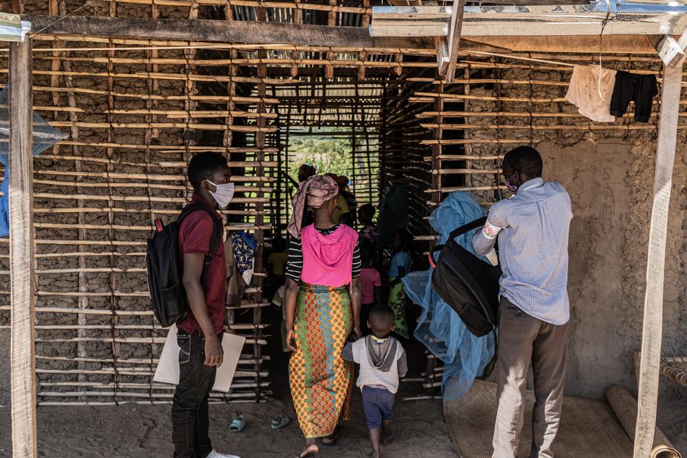 A mental health promoter and a health promoter enter a house which currently houses over 40 people who had fled the armed conflict in Cabo Delgado.