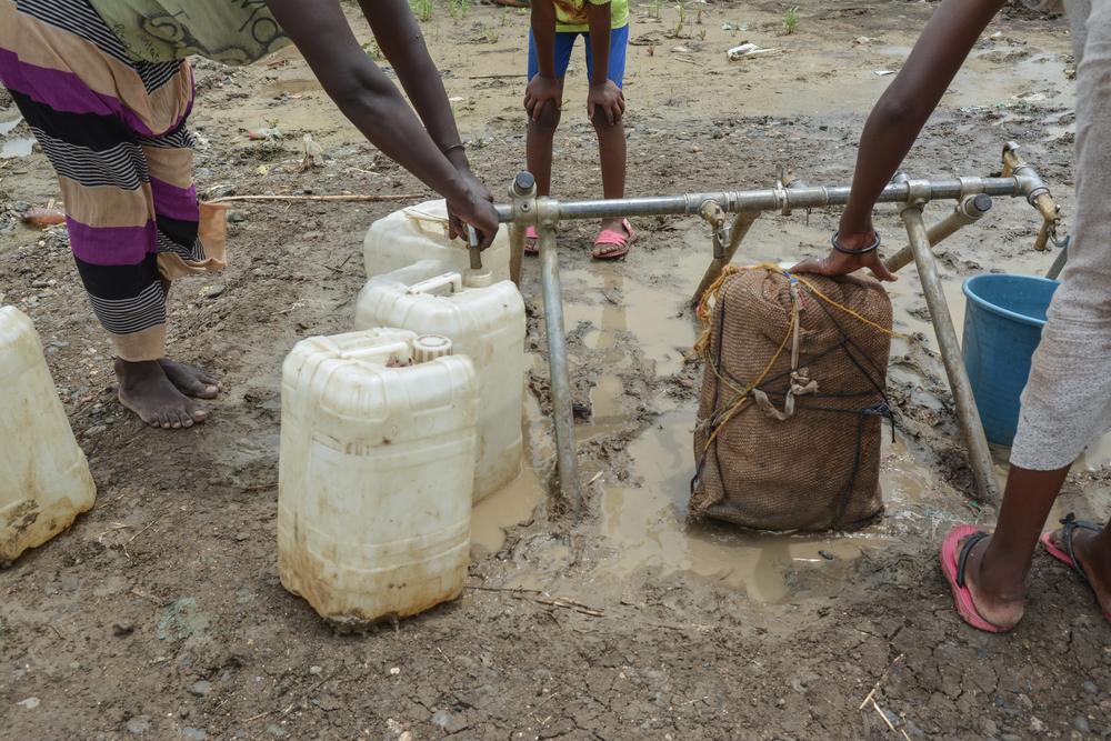 Tigray refugees in Al Tanideba camp fill their jerry cans up at a tap stand. Sudan 2021