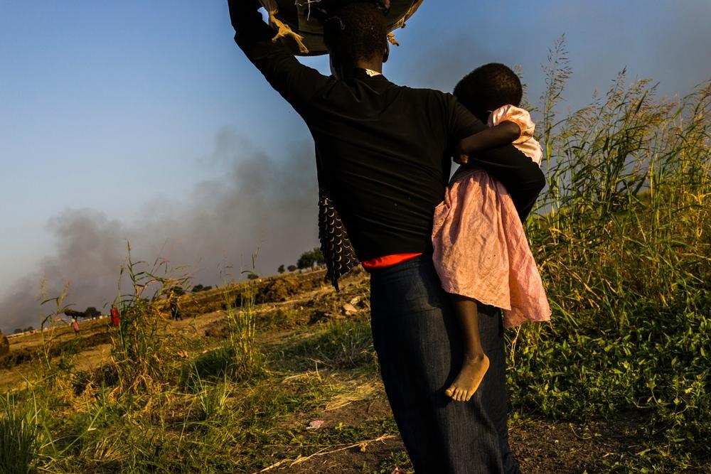 SOUTH SUDAN: Nakoch Tiek Koal (23) carries her 1 1/2 year old daughter, Nyachot Gatluok, in her arms and her 6 month old child Kawai in a basket.