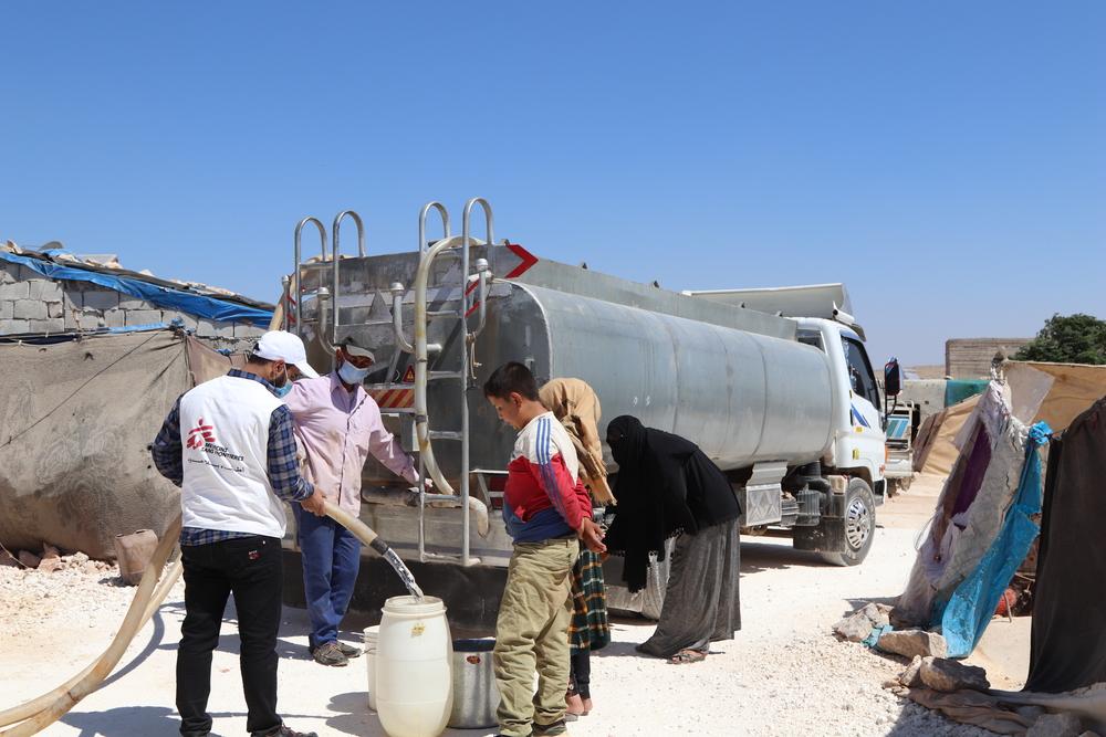 Displaced people are filling their barrels with clean water provided by MSF in a camp in northwest Syria. Syria, 2021. © Abdurzaq Alshami