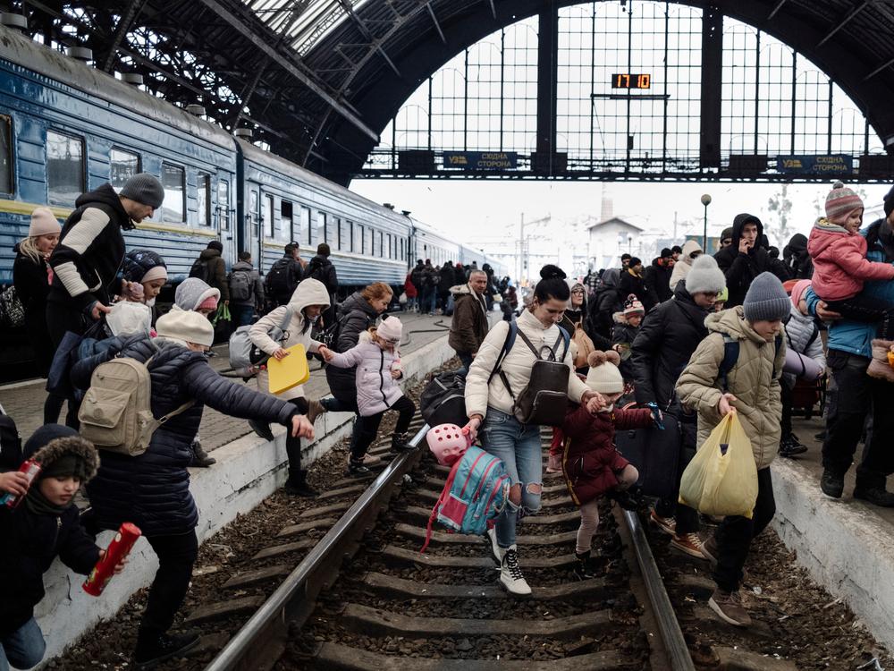 Hundreds of people trying to escape the on-going conflict in Ukraine wait for a train to Poland at the central train station in Lviv.