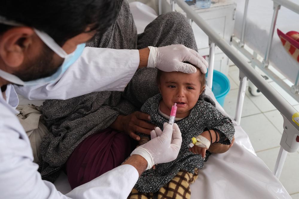 A medic gives glucose to a patient in the measles isolation ward at Boost hospital