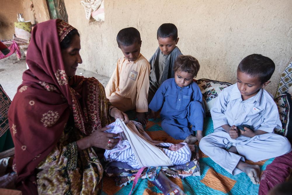 At home, the entire family of nearly 25 people awaits their arrival, where the new baby's aunt introduces her to her brothers and prepares to give her an oil massage, a tradition when a newborn is brought home.