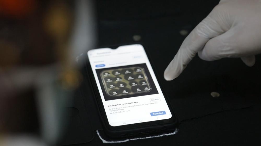 Dr. Nada Malou, program manager and clinical lead at the MSF Foundation, points to a smartphone screen on which the Antibiogo application is open and displays an antibiogram.