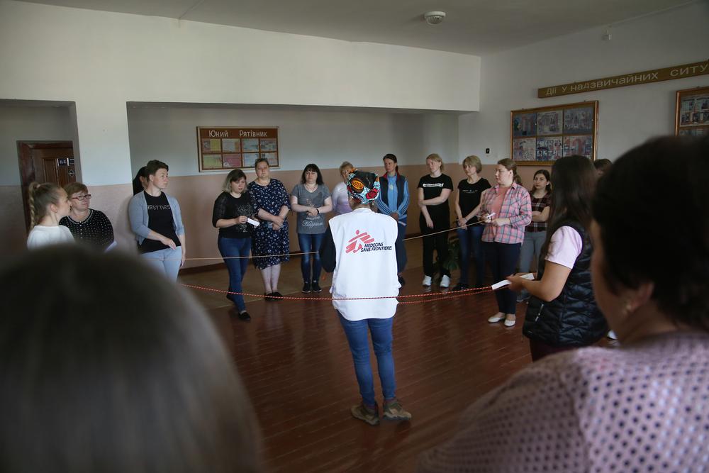 The participants are creating a spider web of string to simulate the bureaucratic challenges survivors of sexual violence face when they try to get assistance.