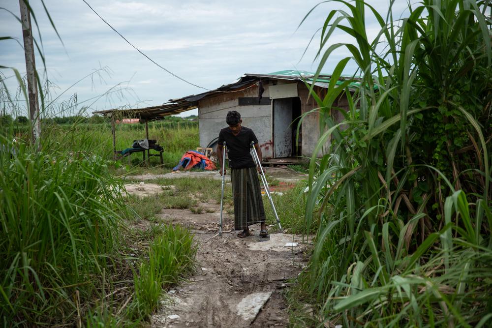 rohingya refugee in malaysia standing in front of his temporary shelter. © MSF