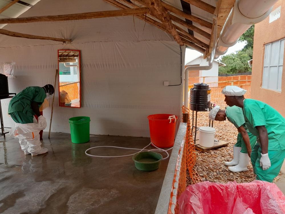 A nurse is safely removing its Personal Protective Equipment (PPE) at Mubende Ebola Treatment Center, after taking care of patients infected with Ebola. Uganda, 2022. © Sam Taylor/MSF