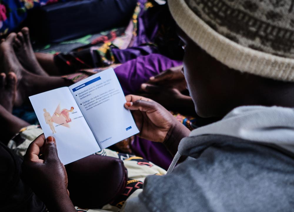 Photo of a patient leafs through a leflet prepared by Doctors Without Border. Malawi, December 2022. © Diego Menjibar