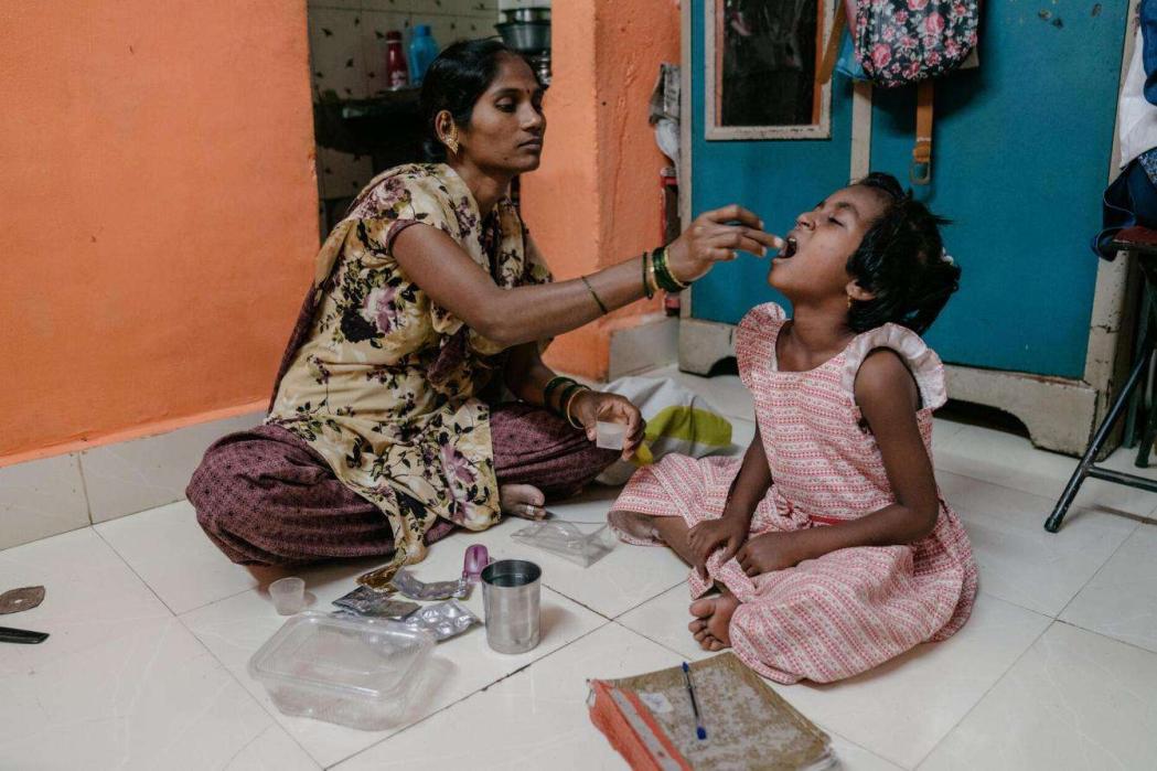 A 7-year-old DRTB (Drug Resistant Tuberculosis) patient being given her TB medication by her mother. India, February 2022. © Prem Hessenkamp