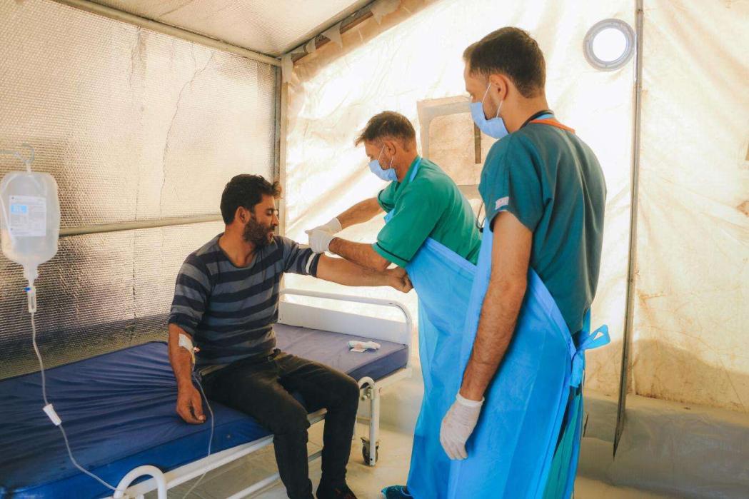 A healthcare worker examining Mohamad Al-Merhi, a Cholera patient in the Doctors Without Borders-supported Cholera Treatment Unit (CTU) in Idlib governorate. Syria, November 2022. © Abd Almajed Alkarh/MSF