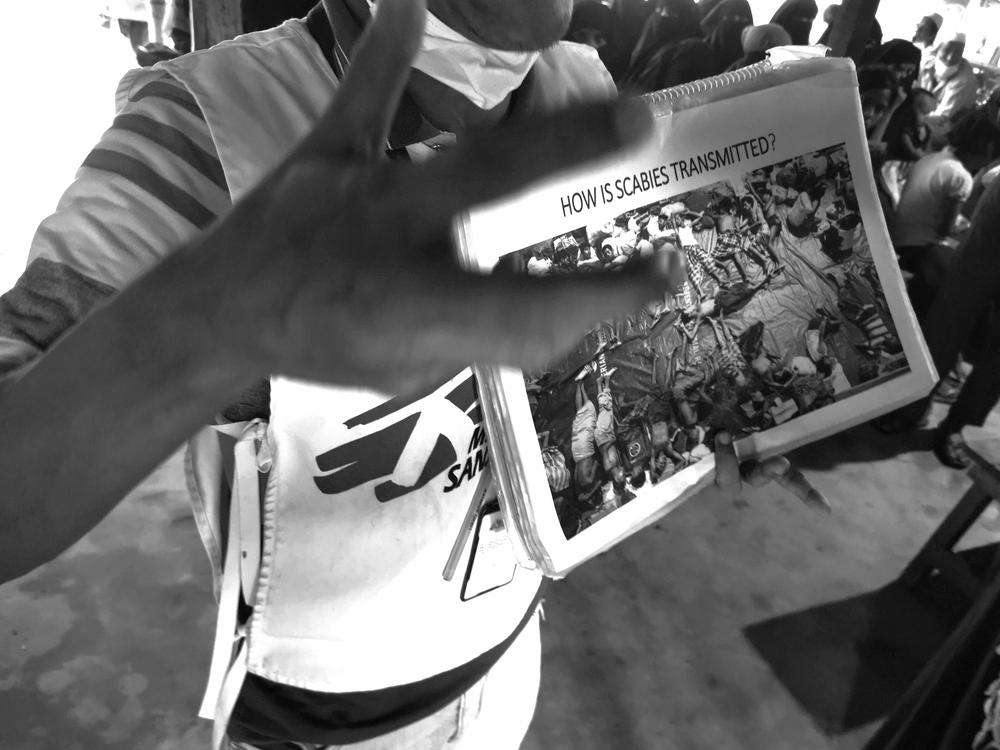 A Doctors Without Borders staff explaining information about scabies in refugee camp in Bangladesh.