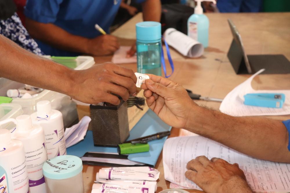 patients suffering from scabies are taking medications and listening to the medicine dispensers about when and how to take medications. Bangladesh, March 2023. © Farah Tanjee/MSF