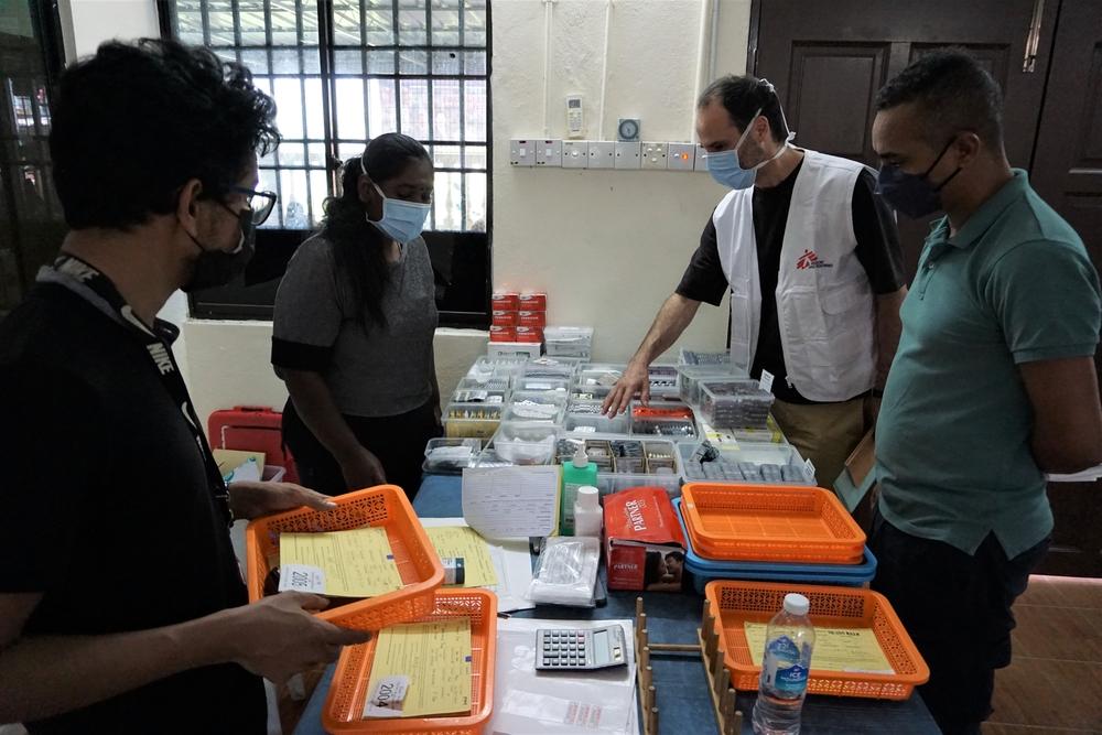Staff show International President Dr. Christos Christou the drugs being dispersed to patients in the mobile clinic supported by Doctors Without Borders in Sungai Dua, Penang, Malaysia © Intan Ali/MSF