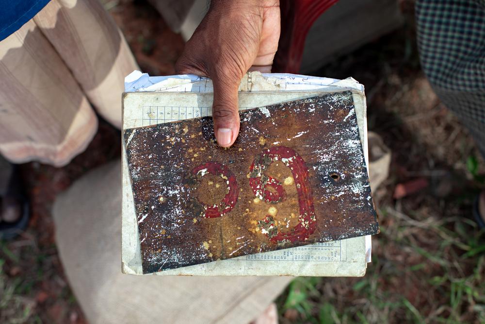 A close-up of the house number in Abdulshakour's hands, a cherished keepsake he holds onto in the hope of returning to his home in Myanmar one day.