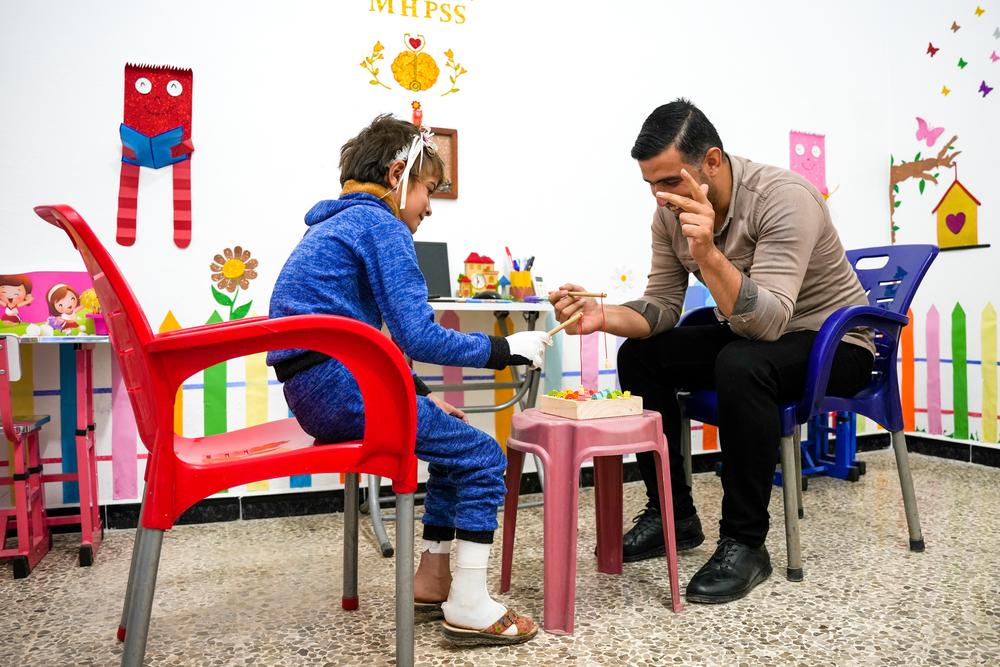 Burn unit mental health team is carrying out recreational activities with seven-year-old patient, to adapt her to her surroundings again after she suffered severe burns to her hands while playing with her brother next to diesel at their home in northwestern Syria. Syria, October 2023. © Abdulrahman Sadeq