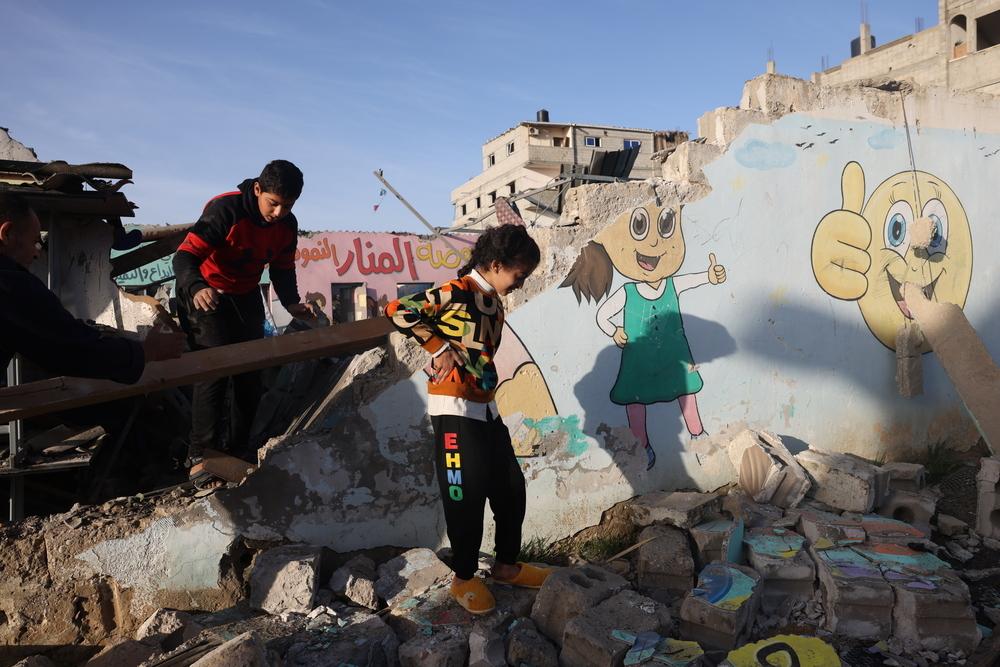 Children walk through the rubble of a destroyed building after it was hit in an Israeli airstrike. Gaza, 24 November 2023. Palestinian Territories, 2023. © Mohammed ABED