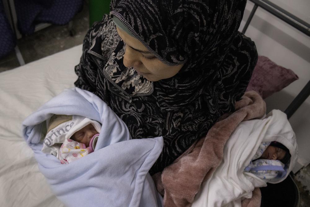 A mother holds her twin babies, born the previous day at Emirati maternity hospital, Rafah. Palestinian Territories, March 2023. © Annie Thibault/MSF
