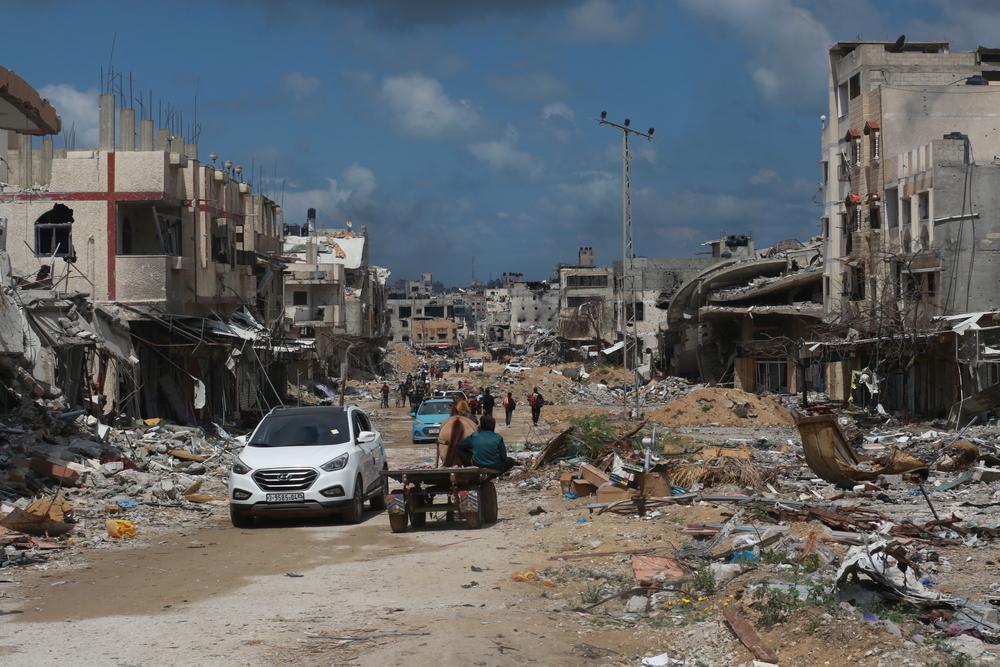 Displaced people walk between destroyed buildings in Gaza. Palestine, 6 May 2024. © MSF