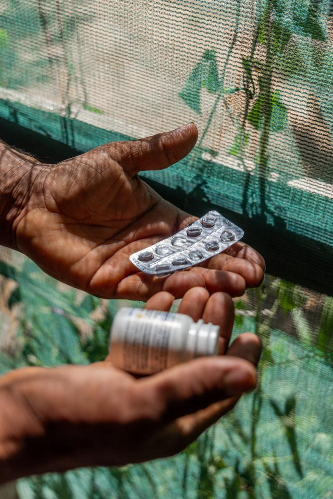 A Syrian refugee in Lebanon holds his empty hypertension medication.