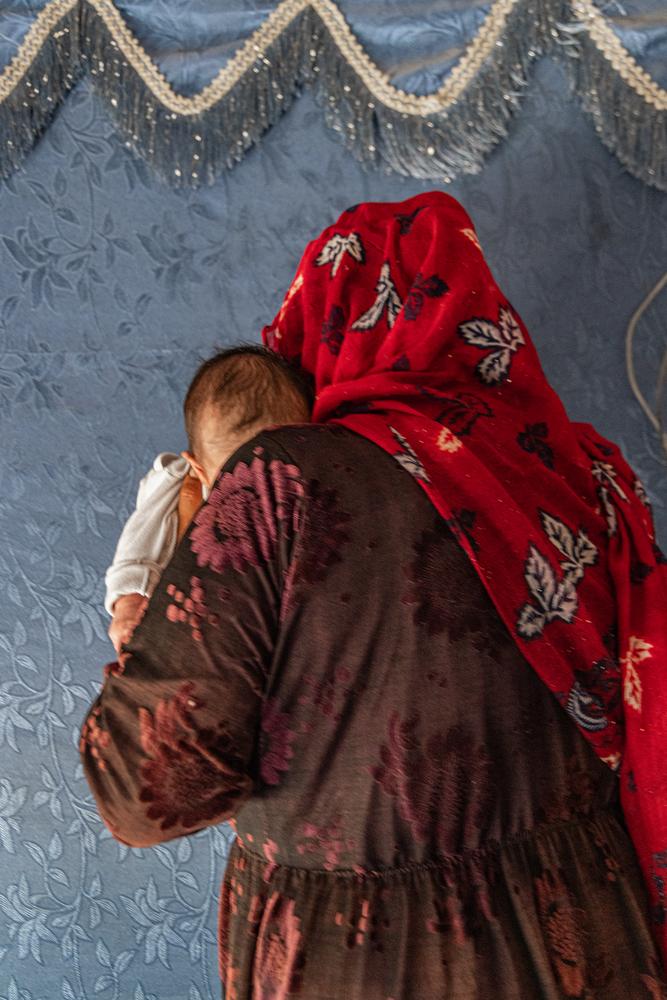 A Syrian refugee holds the month-old baby she helped deliver in Qaa, northeast Lebanon.