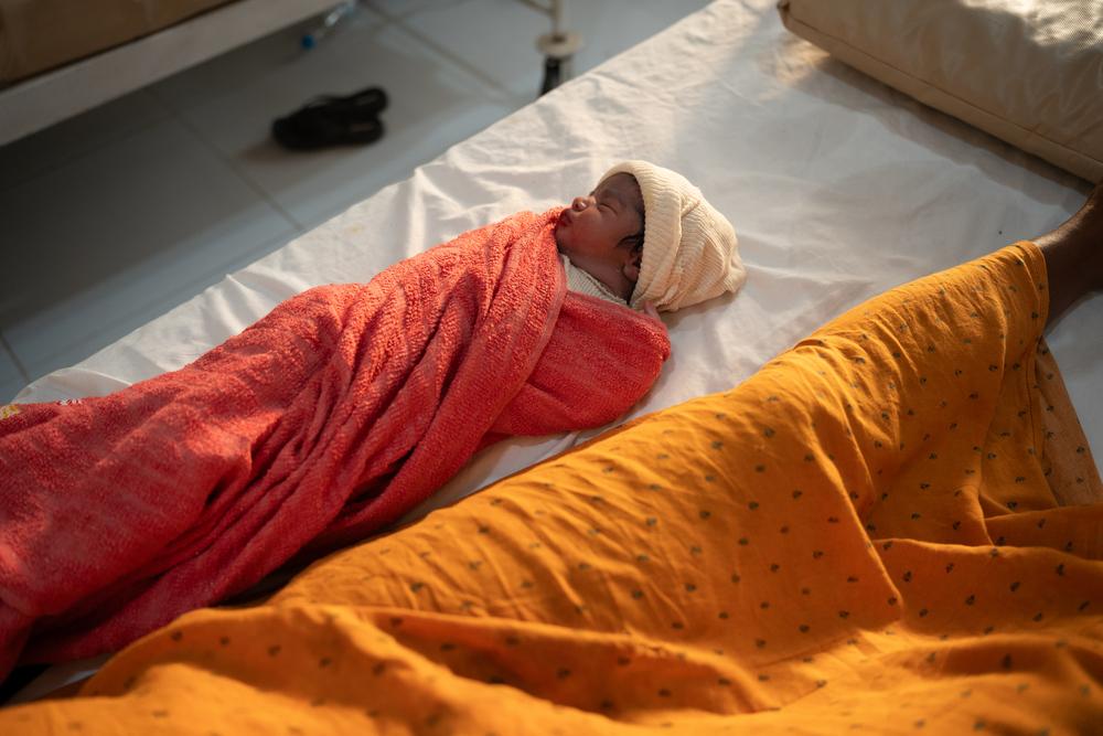A newborn sleeping next to his mother before she is being discharged, 6 hours after delivery.