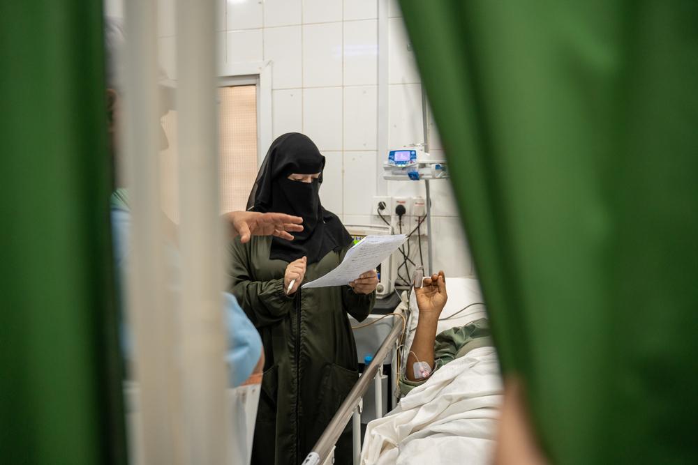 A doctor checking on patients in the intensive care unit.