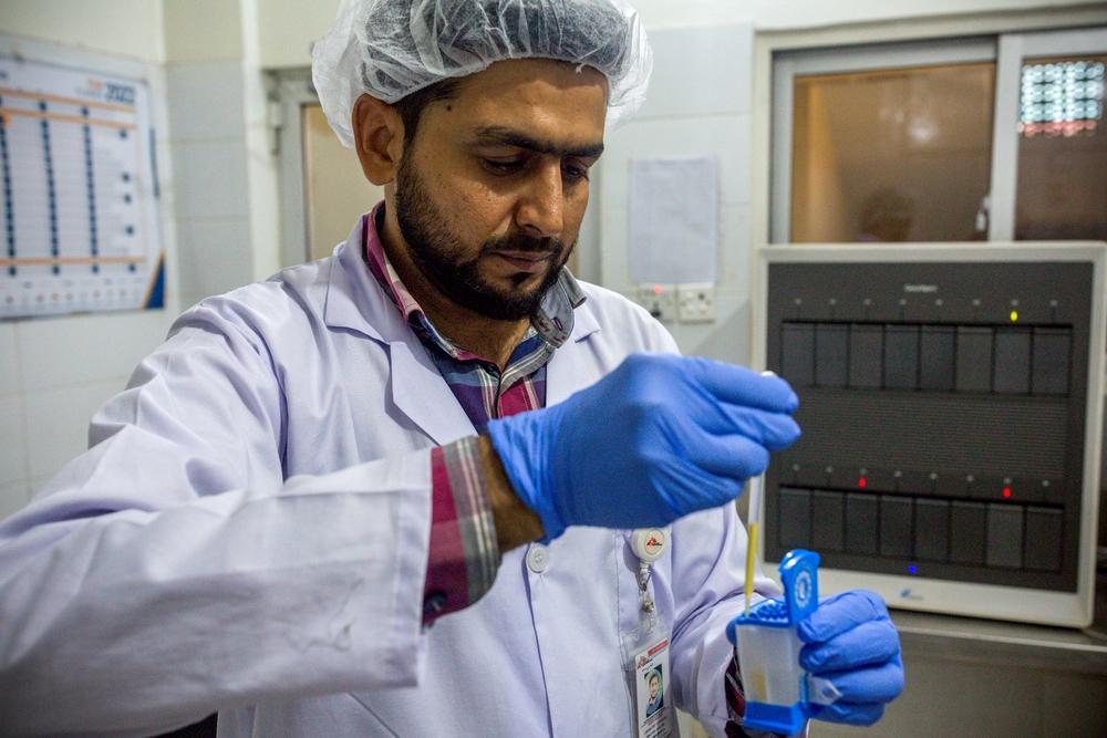 A skilled lab technician carefully sets up a cartridge for accurate hepatitis C testing with the GeneXpert® at the MSF clinic in Machar Colony, Karachi, Pakistan