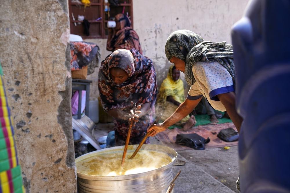 Women cooking inside the Al Tadamon schoolgrounds in El Gedaref State. Sudan, November 2024. © Faiz Abubakr