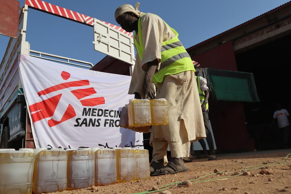 MSF staff offloading the truck to prepare for the distribution in outskirts of Nyala, South Darfur.