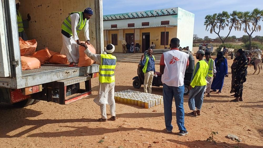 MSF staff offloading the truck to prepare for the distribution in outskirts of Nyala, South Darfur.