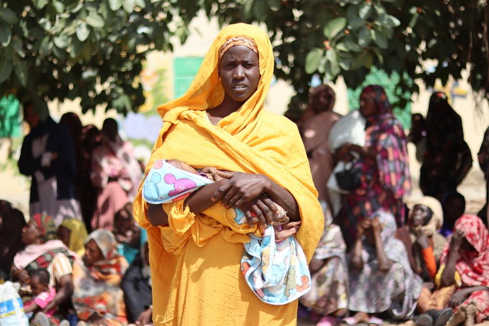 One of the many mothers admitted to Doctors Without Borders' program to care for lactating and pregnant women suffering from severe malnutrition, stands in line waiting for her turn to receive the food basket in Nyala, South Darfur.
