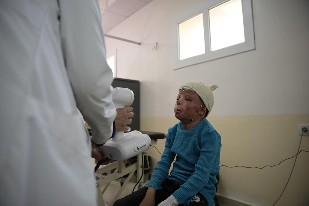 A member of the 3D-printing team takes a facial scan of a young patient with severe facial burns.