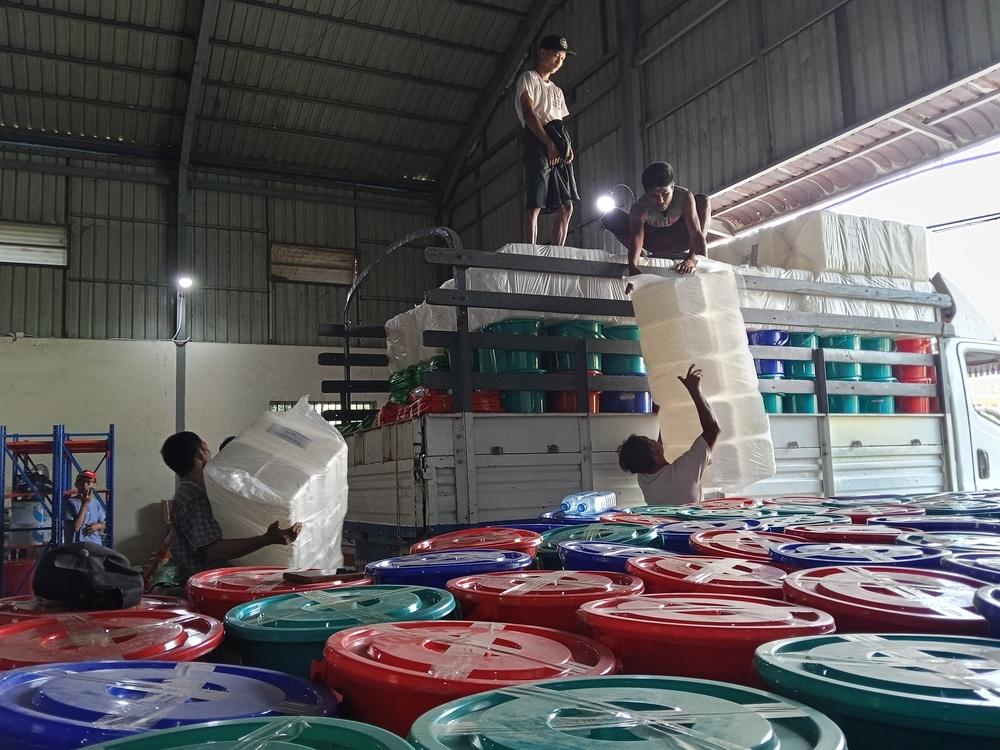 Two trucks are loaded with non-food item kits at our warehouse in Mandalay. Each kit includes essentials such as blankets, tarps, mosquito nets, hygiene items, and household supplies.