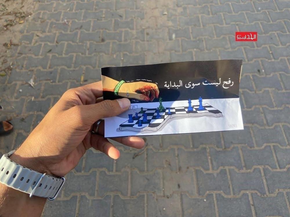 A hand holding a displacement order leaflet