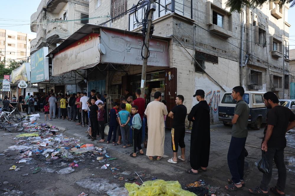 People line up to buy food in Gaza