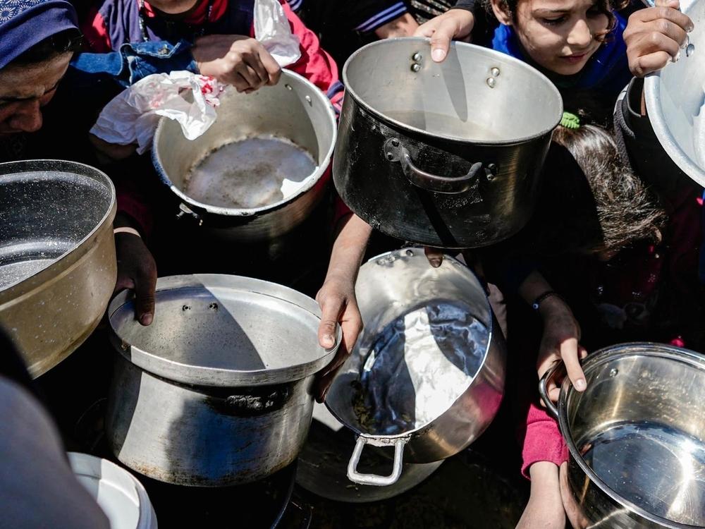 Kids holding their empty pots at a community kitchen in Northern Gaza.