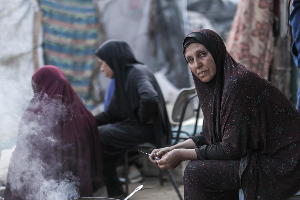 A woman cooks over open flame