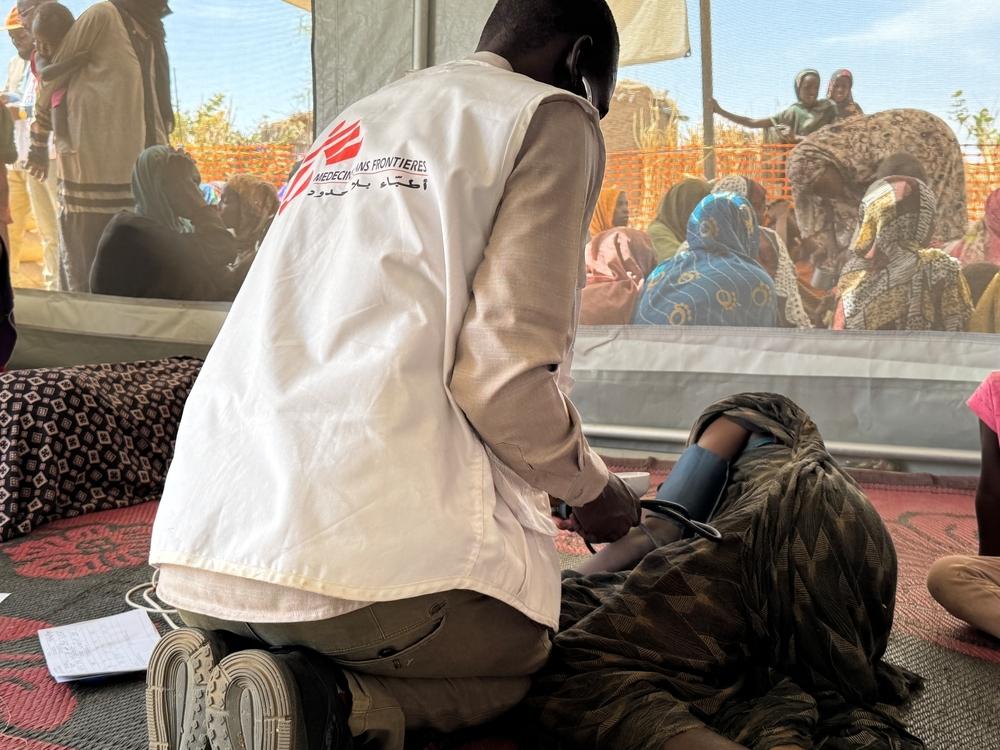 MSF nurse, checks the constants of an elderly woman as she recovers in MSF health post in Tawila Umda.